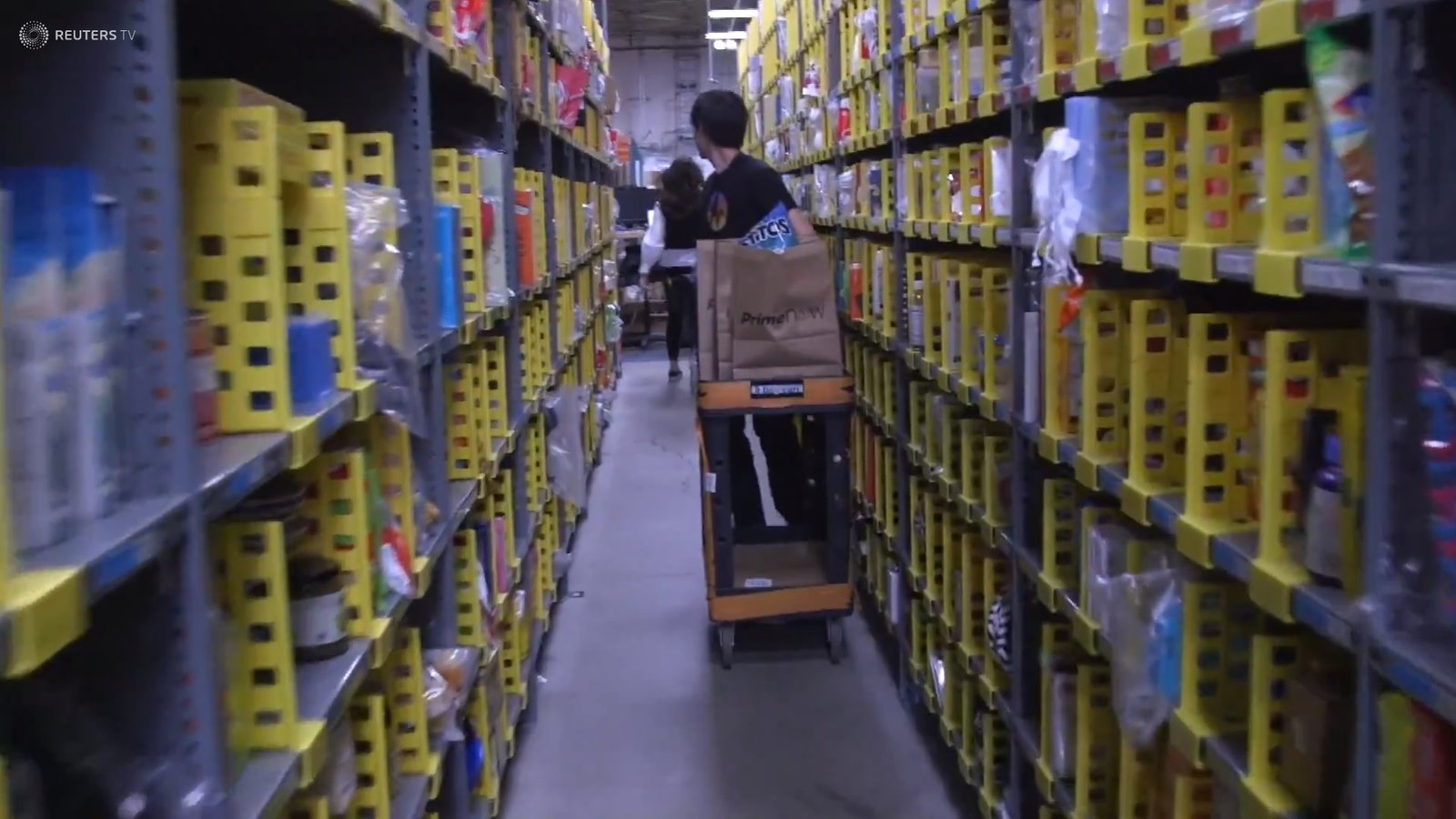 Man running through shelves to fulfill orders.